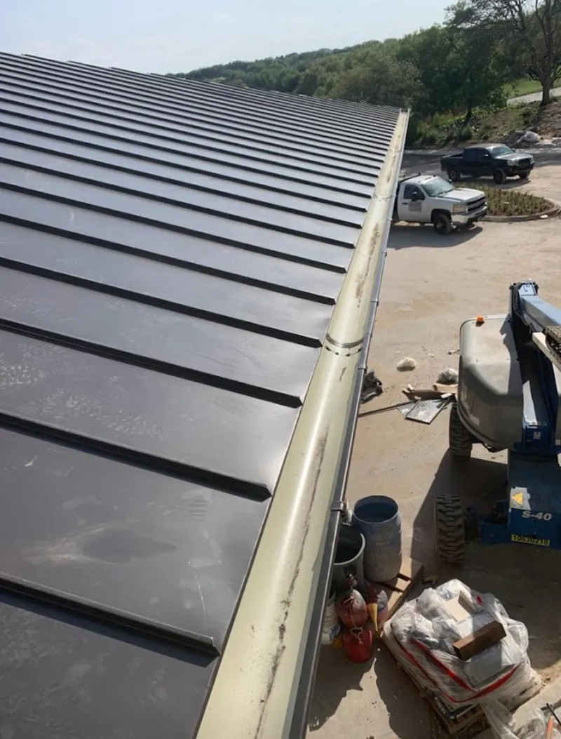 Standing seam panel and gutter detail on a metal roofing jobsite in Easton
